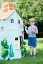 Young Boy Painting Home Made Cardboard House