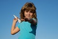 Young boy with paper plane against blue sky. Kid playing with paper airplane on sunny day. Royalty Free Stock Photo