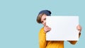 Young boy peeking out from behind white notice board Royalty Free Stock Photo