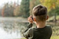 Young boy photographing a lake outdoors Royalty Free Stock Photo