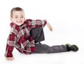 Young boy in plaid shirt laying on his side