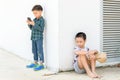 Young boy play smartphone compare with poor boy