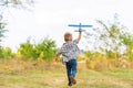 Young boy play with toy airplaine in hands. Happy Kid is playing in park outdoors Royalty Free Stock Photo