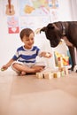 They love playing together. A young boy playing with building blocks in his room while his dog watches. Royalty Free Stock Photo