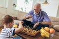 Young boy is playing chess with his grandfather Royalty Free Stock Photo