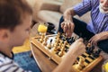 Young boy is playing chess with his grandfather Royalty Free Stock Photo