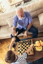 Young boy is playing chess with his grandfather Royalty Free Stock Photo