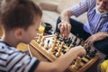 Young boy is playing chess with his grandfather Royalty Free Stock Photo