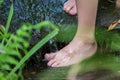 Young boy playing with clear water at a little creek using his feet and the water spring cooling his feet Royalty Free Stock Photo