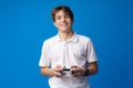 Young boy playing computer games with jojystick against blue background Royalty Free Stock Photo