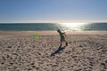 Young boy playing frisbee on beach. Child plays frisbee on the sand on beach near sea. Beach games and active toddler Royalty Free Stock Photo