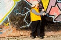 Young boy playing in front of colourful graffiti Royalty Free Stock Photo