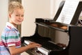 Young boy playing grand piano at home Royalty Free Stock Photo