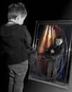 Young boy playing guitar in mirror. Royalty Free Stock Photo