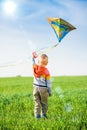 Young boy playing with his kite in a green field. Royalty Free Stock Photo