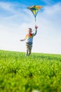 Young boy playing with his kite in a green field. Royalty Free Stock Photo