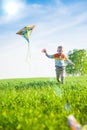 Young boy playing with his kite in a green field. Royalty Free Stock Photo