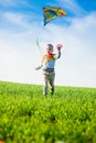 Young boy playing with his kite in a green field. Royalty Free Stock Photo