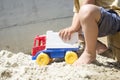 Young Boy Playing with his Plastic Truck Toy on White Sand Royalty Free Stock Photo