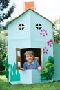 Young Boy Playing In Home Made Cardboard House