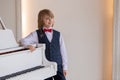 A young boy is playing the piano in a room. Royalty Free Stock Photo