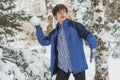 Young boy playing snowball and other winter activities on a snowy day in the park f