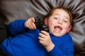 Young boy playing video game laying on couch Royalty Free Stock Photo