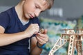 Young boy playing with eco wooden constructor