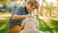 Young Boy Plays with His Loyal Golden Retriever Dog, Scratches His Head, Caresses, Cuddles. Gorgeo Royalty Free Stock Photo