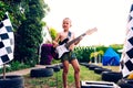 Young boy plays a piece to the electric guitar, very concentrated in his interpretation, dressed in a swimsuit