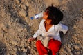 A young boy plays in a pile of dirt in Agra, India.