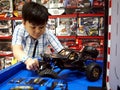 A young boy plays with radio controlled cars in a toy store.