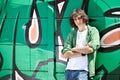 Young boy posing against a graffiti wall