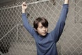 Young boy posing on a chain-link fence Royalty Free Stock Photo