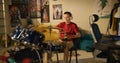 Young boy practices musician skills using drum kit