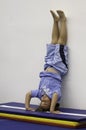 A young boy practices standing on his head in acrobat school