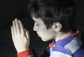 Young boy praying with innocent faith to his God, religious concept