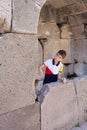 Young boy pretending to be a zombie in the ancient bath of Pergamon, Turkey