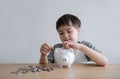 Young boy putting coins into piggy bank, Child counting saving money, Kid holding coin on his hands, Children learning financial Royalty Free Stock Photo