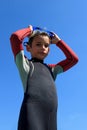 Young boy ready for diving in diving suit puts on diving mask