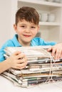 Young Boy Recyling Newspapers At Home