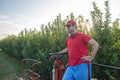 Young boy in a red t-shirt and cap drives an apple picker in a fruit field Royalty Free Stock Photo