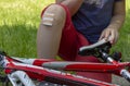 Injured boy with white cotton dressing bandage beside bike