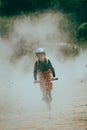 A young boy is riding a bicycle through a smoky field with a focused expression Royalty Free Stock Photo