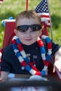 Young boy riding in red wagon having fun in the park for July Fourth Royalty Free Stock Photo