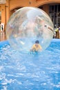 Young boy in rubber ball floating on water