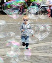 Young boy run after soap bubbles and catch them