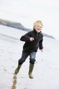 Young boy running on beach smiling Royalty Free Stock Photo