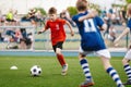 Young Boy Running Fast and Kicking Soccer Ball on Grass Pitch. Football Tournament For Youth School Teams. Royalty Free Stock Photo