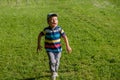 Young boy runs in a green field. Cute child running across park outdoors grass Royalty Free Stock Photo